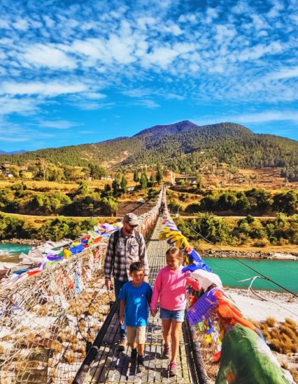 A family crossing a suspension bridge in Bhutan
