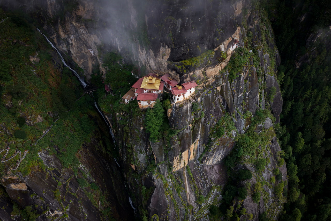 Tiger's Nest hike aerial view showing the monastery built into the cliff above Paro valley, Bhutan