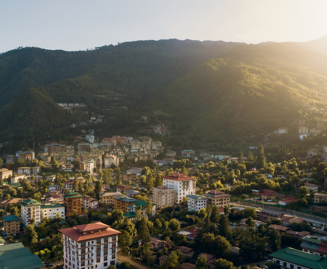 Aerial view of a Bhutanese town and valley showing traditional architecture and forested hills