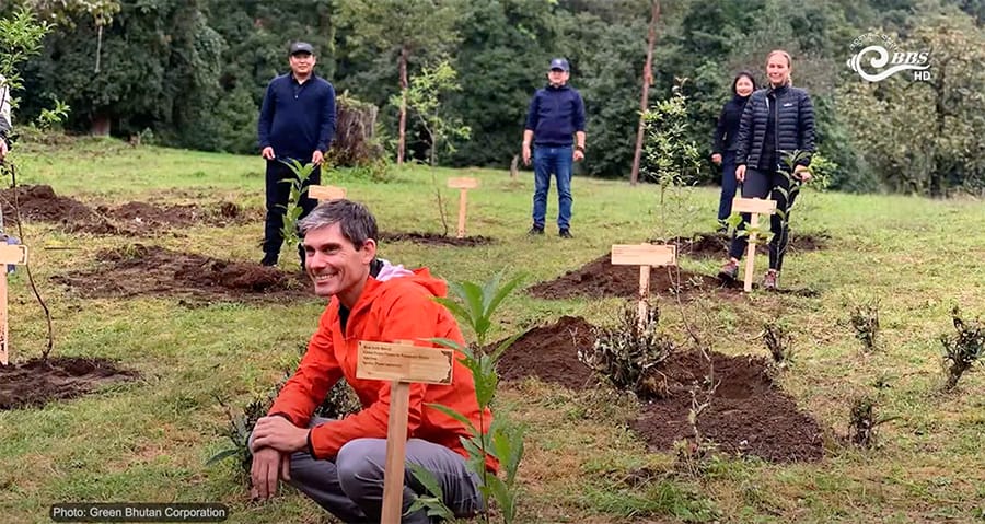 Planting a native tree sapling with a local guide in Bhutan