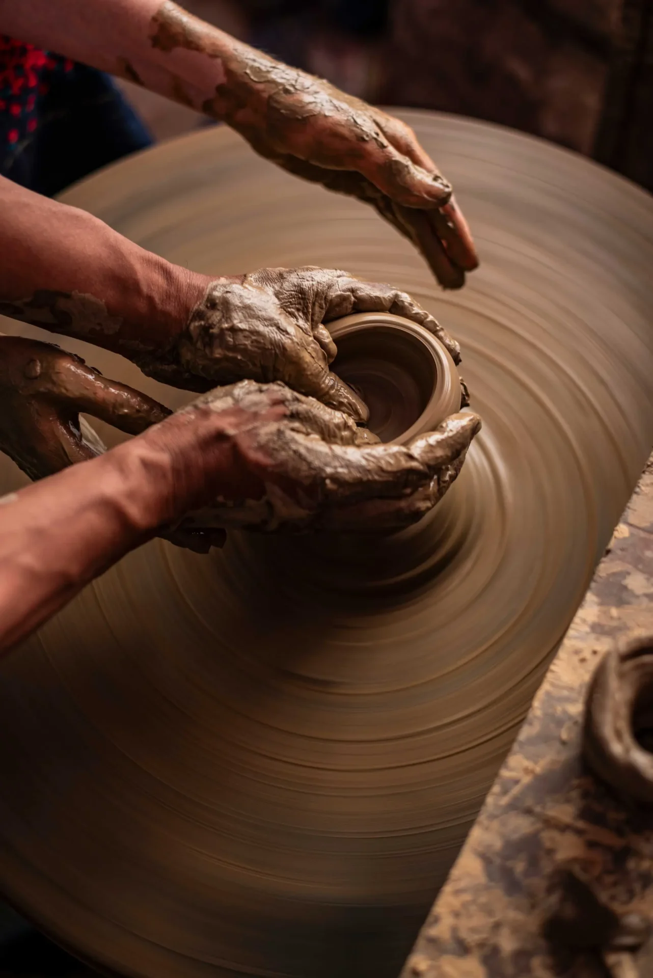 Hands shaping clay at a pottery class in Bhutan